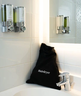 secador de pelo en la ducha de una habitación del OSKO Hotel Toulouse-Blagnac