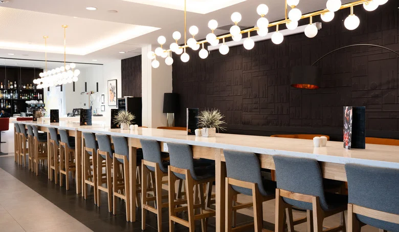 bar del OSKO Hotel Toulouse-Blagnac con gran mesa y ambiente acogedor